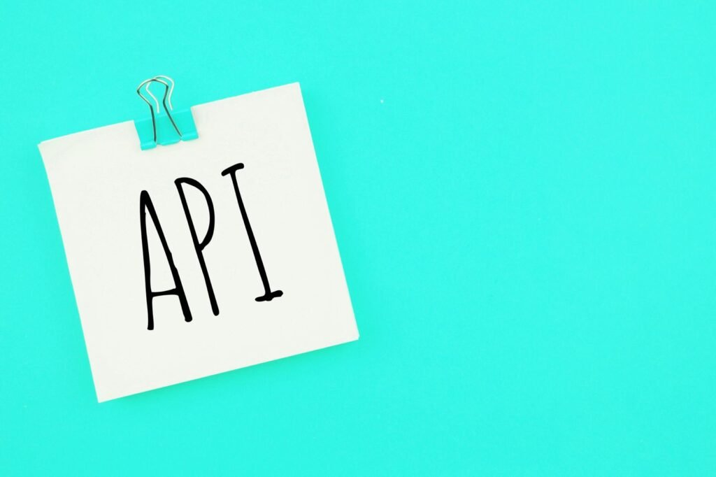 SEO A paper note with the acronym "API" written on it, clipped with a binder clip, against a turquoise background.