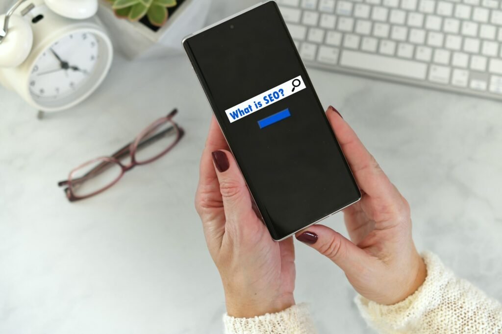 female holding phone with search screen what is seo search engine optimization